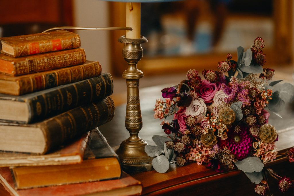 tradition de mariage le bouquet de la mariée posé sur une table avec un chandelier et des livres