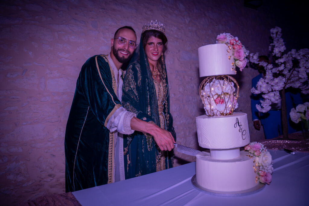 Saison 2022 couple de mariés en tenue traditionnelle marocaine qui découpent le gâteau