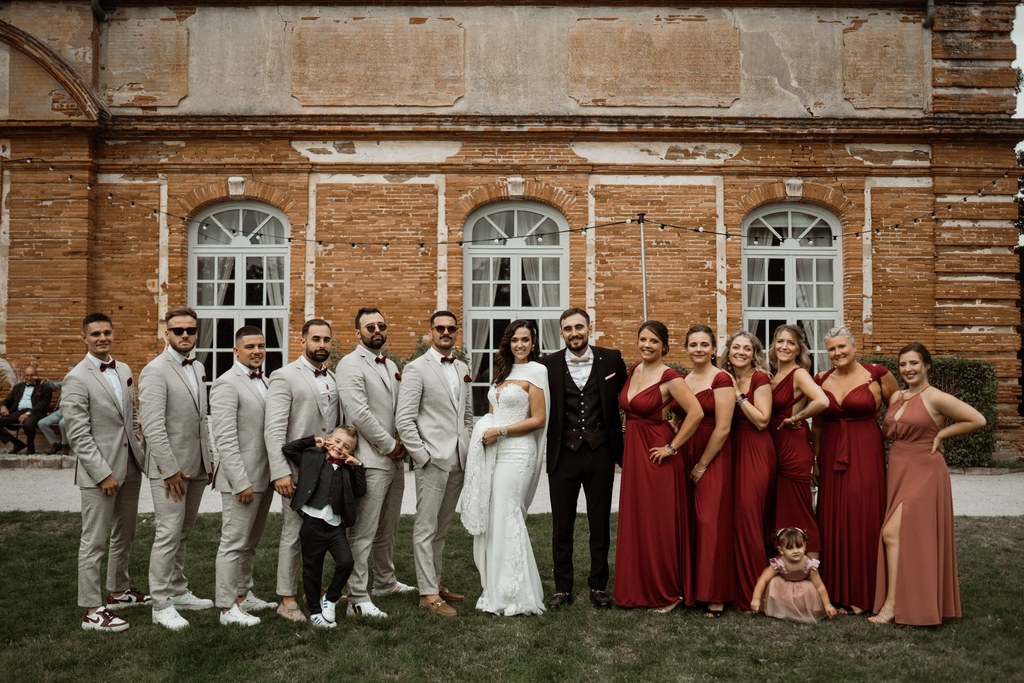 Cortège mariage photo de groupe des mariés avec les garçons et des filles d'honneur en beige et bordeaux alignés