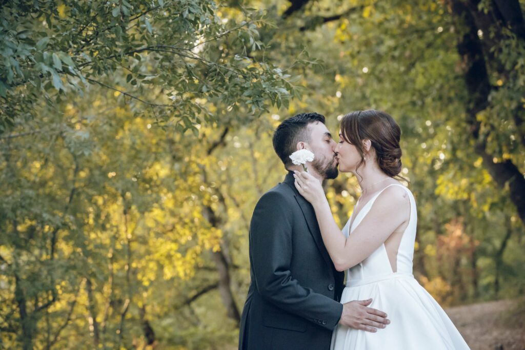 Lune de miel couple de mariés lors de sa séance couple dans les arbres qui s'embrassent