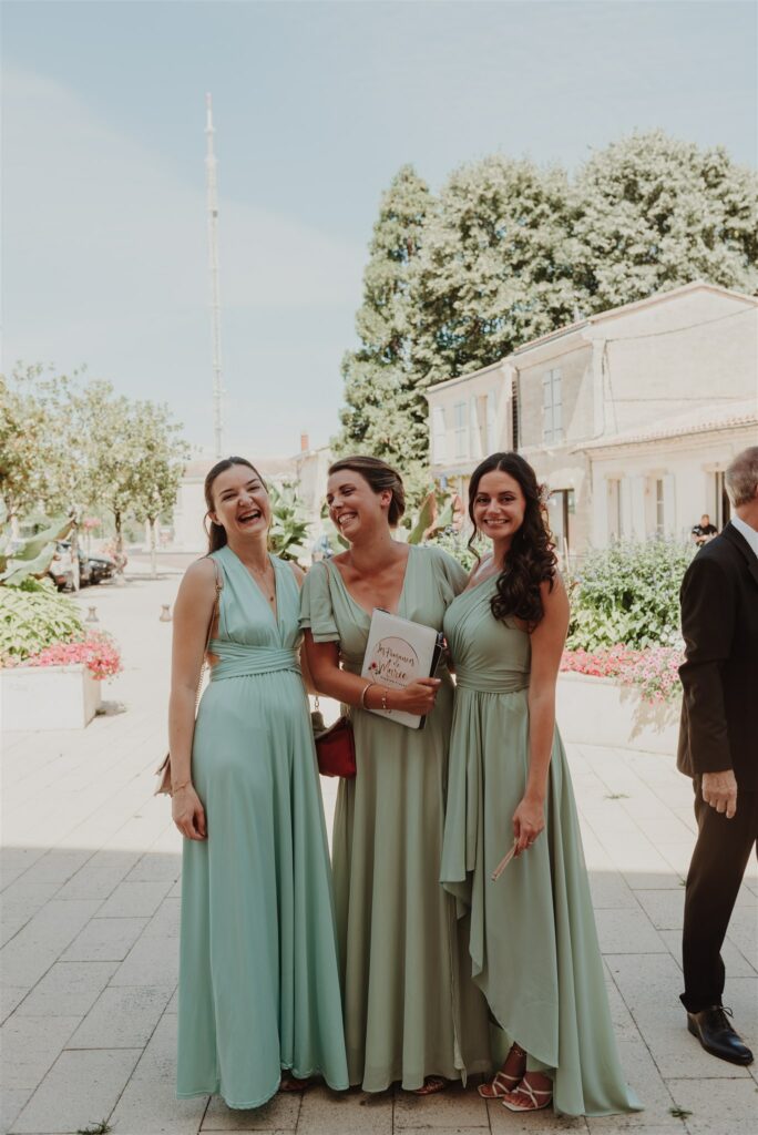 Témoin de mariage 3 jeunes filles alignée en robe verte qui prennent la pause
