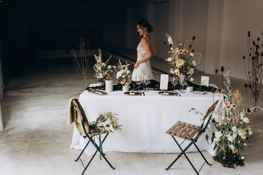 Mariée, qui découvre sa table d'honneur, fleurieet avec la céramique rentrée à l'intérieur pour cause de mauvais temps