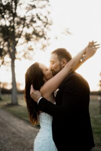 Lune de miel séance couple au coucher du soleil. Les mariés s'embrassent