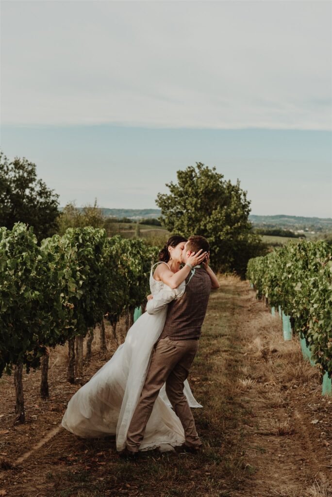 Cérémonie laïque la marié qui porte la mariée dans une vigne et ils s'embrassent